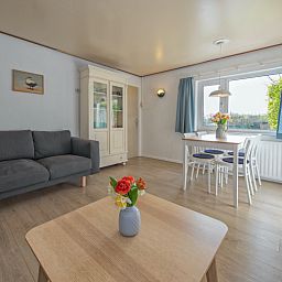 Gemuetliches Wohnzimmer des Ferienhauses Swalefie in De Dennen, Texel mit Blick auf die Natur.