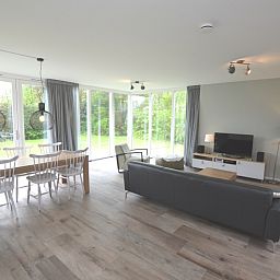 Bright living room of Tempelierweg 16 - de Brunaire, vacation home in De Dennen, Texel overlooking green garden.