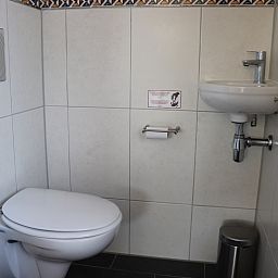 Compacte badkamer in Vakantiehuis Gortersmient 216, De Dennen, Texel met toilet en wastafel.