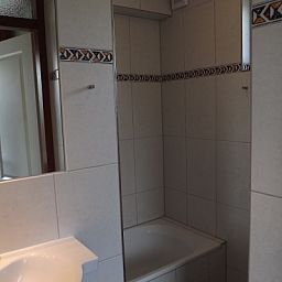 Stijlvolle badkamer in Vakantiehuis Gortersmient 216, De Dennen, Texel met bad en moderne tegels.