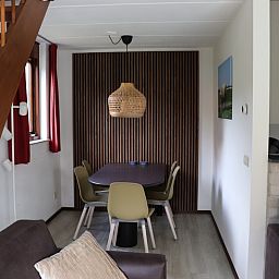 Gezellige eethoek in Vakantiehuis Gortersmient 216, De Dennen, Texel met houten tafel en stoelen.