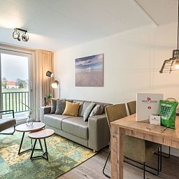 Moderne Sitzecke im Appartement Bos en Duin 32, De Dennen, Texel mit Blick auf die Natur.