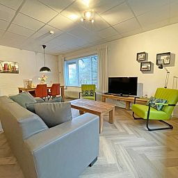 Stylish sitting area in Apartment Bos en Duin 04, De Dennen, Texel with flat-screen TV and colorful accents.