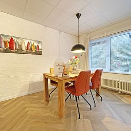 Dining area with artwork in Apartment Bos en Duin 04, De Dennen, Texel, ideal for cozy meals.