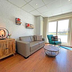Helles Wohnzimmer des Appartements Bos en Duin 18 in De Dennen, Texel, mit modernen Moebeln und herrlicher Aussicht.