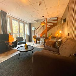 Geraeumiges Wohnzimmer im Appartement Bos en Duin 24, Texel mit Blick auf die Natur von De Dennen, ideal zum Entspannen.