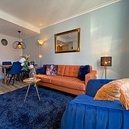 Dining area in Apartment Bos en Duin 27, De Dennen, Texel with wooden table and stylish chairs, ideal for cozy meals.