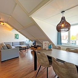 Stylish dining area in Apartment Bos en Duin 33, De Dennen, Texel with wooden dining table and atmospheric lighting.