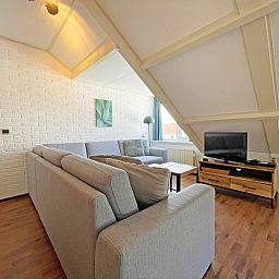 Comfortable sitting area with television in Apartment Bos en Duin 33, De Dennen, Texel for relaxing evenings.