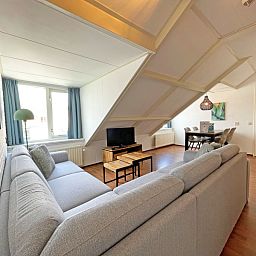 Spacious living room with large windows in Apartment Bos en Duin 33, De Dennen, Texel offers views of the surroundings.