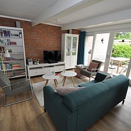 Gemuetliches Wohnzimmer von Bungalow Verste Coogh 62 in De Dennen, Texel mit bequemer Sitzecke.