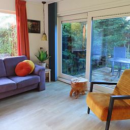 Gemuetliches Wohnzimmer des Ferienhauses Dunkonijn in De Dennen, Texel mit Blick auf den Garten.