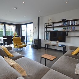 Lichte woonkamer met grote ramen in vakantiehuis 't Hoogelandt 98 - Zeelust, De Dennen, Texel.