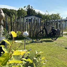 Quiet garden with bicycle at Chalet Wulk, Holiday Park de Bremakker, Texel, surrounded by natural beauty in De Dennen.