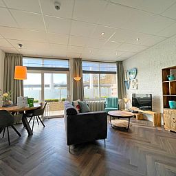 Cozy sitting area in Apartment Bos en Duin 02, De Dennen, Texel with comfortable sofas and cozy decorations.