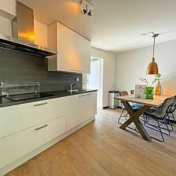 Moderne Kueche im Appartement Bos en Duin 09, De Dennen, Texel mit Essecke und stilvoller Einrichtung.