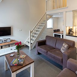 Moderne zithoek met open keuken in vakantiehuis Gortersmient 224, Bungalowpark Gortersmient, De Dennen, Texel. Comfort op de Waddeneilanden.