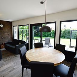 Eethoek in Tempelierweg 17 vakantiehuis, De Dennen, Texel, met tuinzicht en comfortabel meubilair.