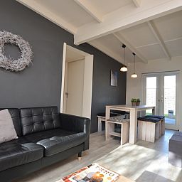 Offener Wohnbereich im Bungalow 't Hoogelandt 24, De Dennen, Texel mit Ess- und Sitzecke, ideal fuer Familienaufenthalte.