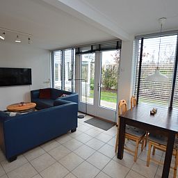 Gemuetliches Wohnzimmer im Ferienhaus de Parel 244, De Dennen, Texel mit Blick auf den Garten, ideal fuer Entspannung auf den Watteninseln.