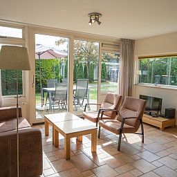 Sunny living room of Bungalow Uterste Coogh 98 in De Dennen, Texel overlooking the garden.