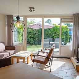 Cozy sitting area in Bungalow Uterste Coogh 98, De Dennen, Texel with access to the terrace.