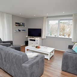 Comfortabele zithoek in Vakantiehuis de Parel 168, De Dennen, Texel met uitzicht op de tuin.