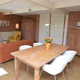 Gemuetliches Wohnzimmer von Bungalow Verste Coogh 64 in De Dennen, Texel mit Esstisch aus Holz.