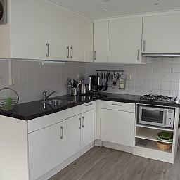 Moderne Kueche im Ferienhaus Gortersmient 234, De Dennen, Texel mit allen Annehmlichkeiten fuer einen komfortablen Aufenthalt.