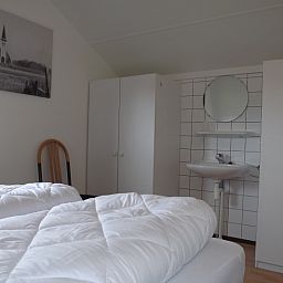 Schlafzimmer mit Waschbecken im Ferienhaus Gortersmient 234, De Dennen, Texel fuer zusaetzlichen Komfort.