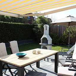 Gezellig terras met zonnescherm bij Vakantiehuis Gortersmient 256 in De Dennen, Texel.