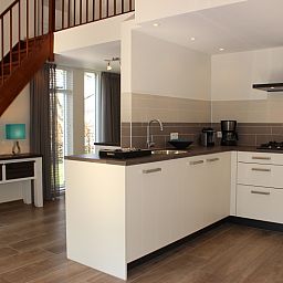 Moderne keuken in Vakantiehuis Gortersmient 256, De Dennen, Texel met open trap.