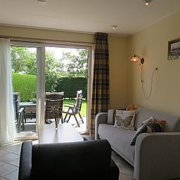 Gemuetliches Wohnzimmer im Bungalowpark Uterste Coogh, Bungalow 114 in De Dennen, Texel, mit Blick auf den Garten.