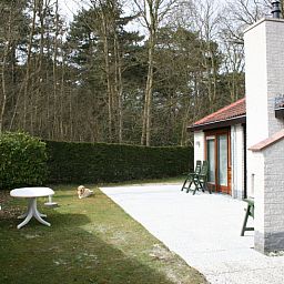Terrasse des Ferienhauses Gortersmient 354 mit Gartenmoebeln und gruener Umgebung in De Dennen Texel.