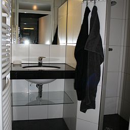 Modernes Badezimmer im Ferienhaus Gortersmient 354 mit Waschbecken und Spiegel in De Dennen Texel.