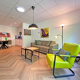 Stijlvolle zithoek in Appartement Bos en Duin 05, De Dennen, Texel met comfortabele meubels en sfeervolle verlichting.