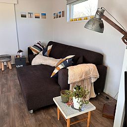 Cozy living room in Holiday Park de Bremakker - Bosveld 141, Texel with comfortable sofa and stylish furnishings.