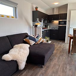Vakantiepark de Bremakker - Bosveld 141, Texel, open kitchen and living room with comfortable sofa and dining area.
