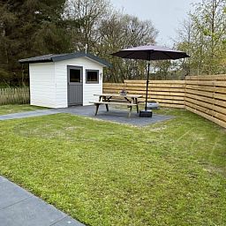Geraeumiger Garten mit Picknicktisch und Schuppen im Vakantiepark De Bremakker - Chalet 1140 in De Dennen, Texel.