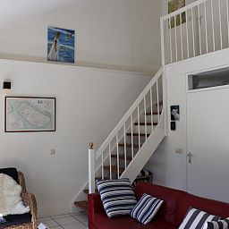 Innenansicht des Ferienhauses Gortersmient 358 in De Dennen, Texel mit Treppe zum Obergeschoss.