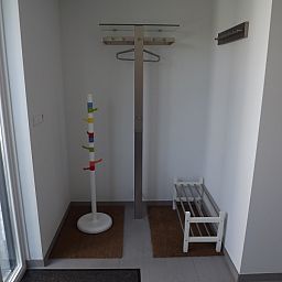 Ingang van Vakantiehuis Gortersmient 320, De Dennen, Texel met praktische kapstok en schoenenrek, ideaal voor een georganiseerde vakantie.