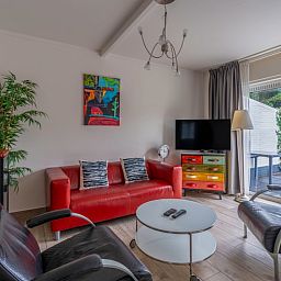 Cozy living room of Bungalowpark 't Luwe Land - Texelfan, De Dennen, Texel. Modern decor with colorful accents.