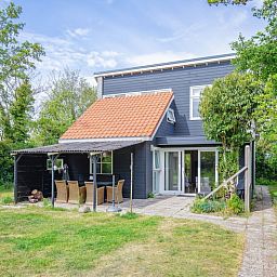 Vakantiehuis Bungalowpark Gortersmient - Blommenzee in De Dennen, Texel met groene omgeving en terras.