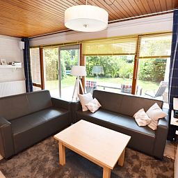 Lichte woonkamer met uitzicht op tuin in vakantiehuis Tempelierweg 10, Texel.