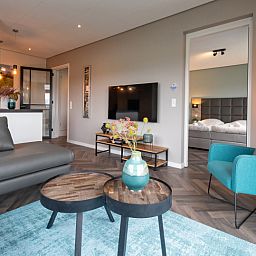 Gezellige zithoek in Appartement Bos en Duin 01, De Dennen, Texel met toegang tot slaapkamer.