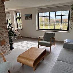 Helles Wohnzimmer in 't Seumerhuussie, Ferienhaus De Dennen Texel, mit moderner Einrichtung und Gartenblick.