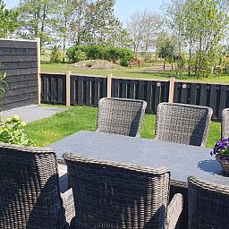Sunny terrace at Helianthus vacation home in De Dennen, Texel overlooking nature.