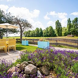 Gezellige tuin bij Boszicht vakantiehuis in De Dennen, Texel met lavendel en uitzicht op natuur.