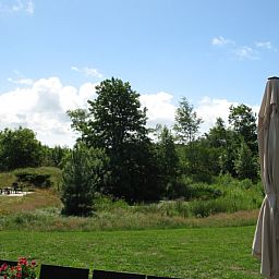 View from Vijverhof vacation home in De Dennen, Texel of green fields and blue sky.