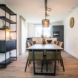 Dining room in Holiday Park De Koorn-aar Villa, De Dennen, Texel with modern furnishings.